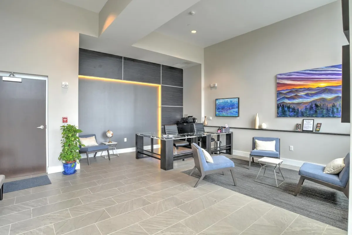 This image captures the building’s reception area, featuring a modern reception desk, contemporary wall art, and a welcoming seating area. The design is clean and professional, conveying a sense of security and hospitality immediately upon entering the building.